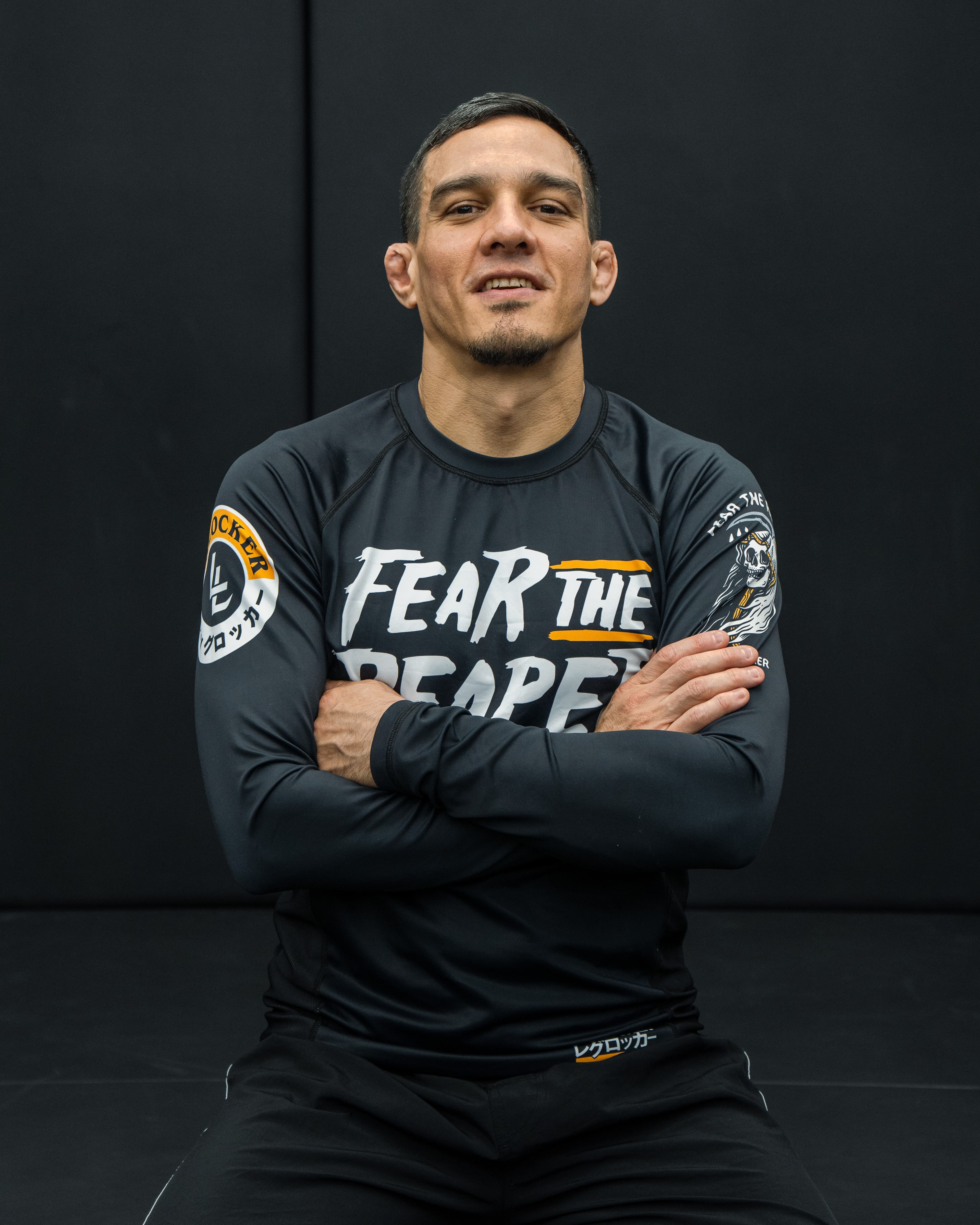 Coach Jake Tapia seated with arms crossed
